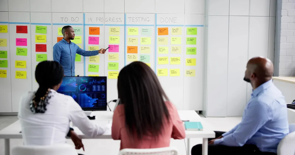An instructor walking a cohort through a delivery board of tasks in progress